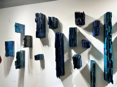 A sculptural installation showing various blocks of blue-painted wood.