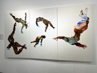 A mostly-white painting white figures made of collaged dyed paper. The figures are caught in a dance.