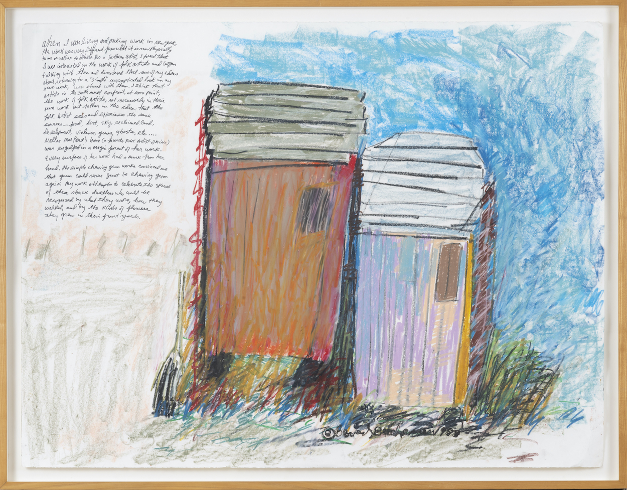 A large framed drawing depicts, in pastel, two small structures adjacent to each other. In the left third of the drawing is a paragraph of handwritten text.