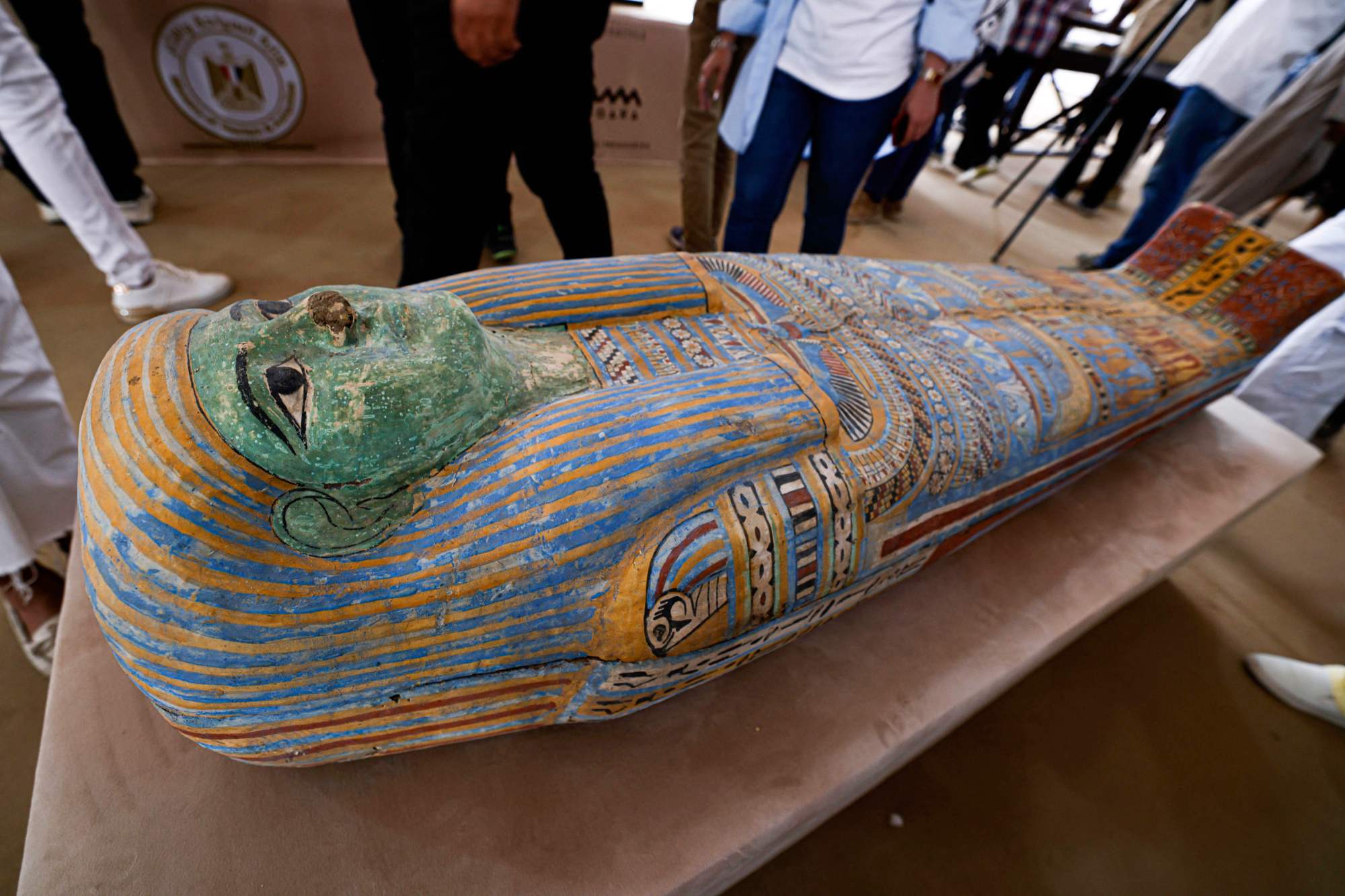 Visitors observe a newly discovered sarcophagus in the Saqqara necropolis, where archaeologists unearthed two human and animal embalming workshops as well as two tombs, south of Cairo on May 27, 2023. The head of Egypt's Supreme Council of Antiquities, told reporters the embalming workshops, where humans and animals were mummified, "date back to the 30th dynasty" which reigned around 2,400 years ago. (Photo by Khaled DESOUKI / AFP) (Photo by KHALED DESOUKI/AFP via Getty Images)