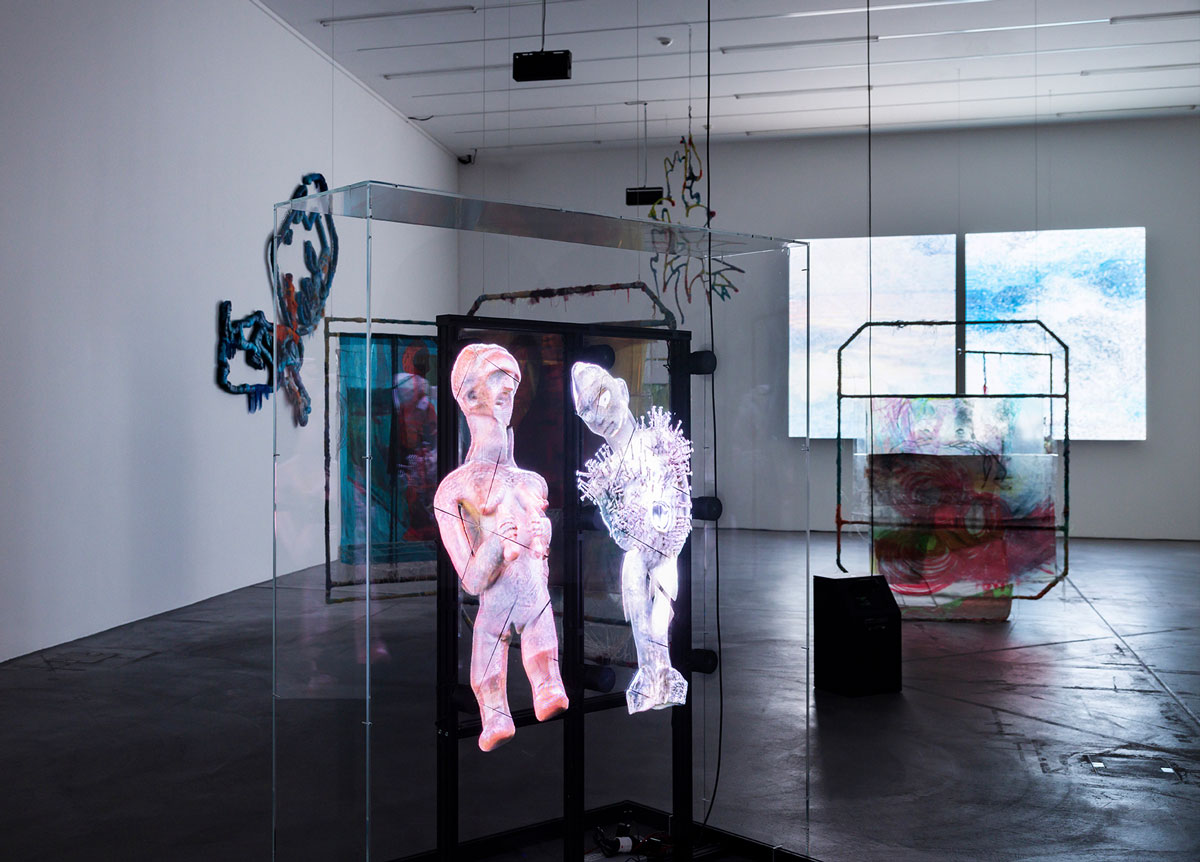 Installation view of a vitrine with a hologram figure. 