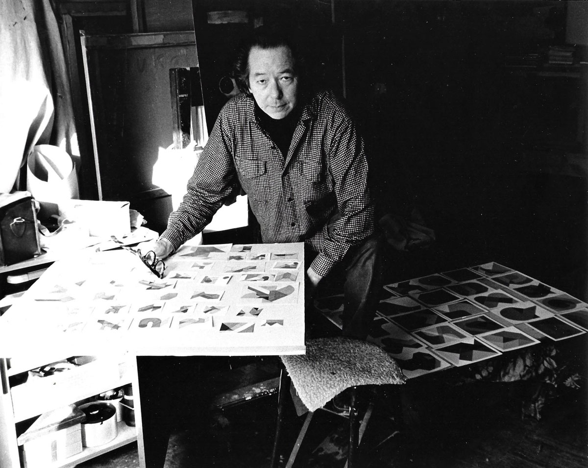 Portrait of Kyohei Inukai at work, surrounded by several drawings.