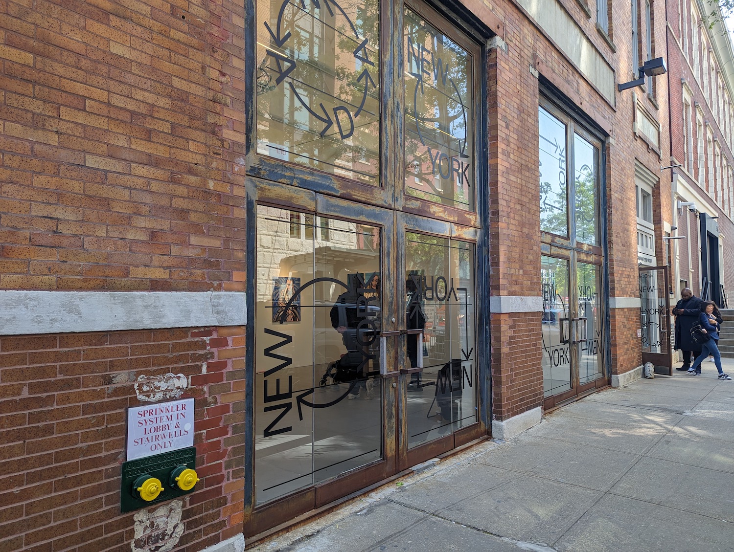 A brick facade with large square glass windows show the words "New Art Dealers Alliance."