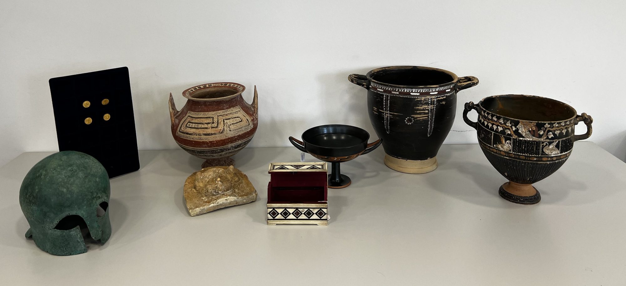Several of the artifacts that Germany returned to Italy on June 5, 2023 after they had been stolen from Italian museums or taken from illegal excavations. They include a bronze helmet, a kylix bowl, and ancient gold coins.