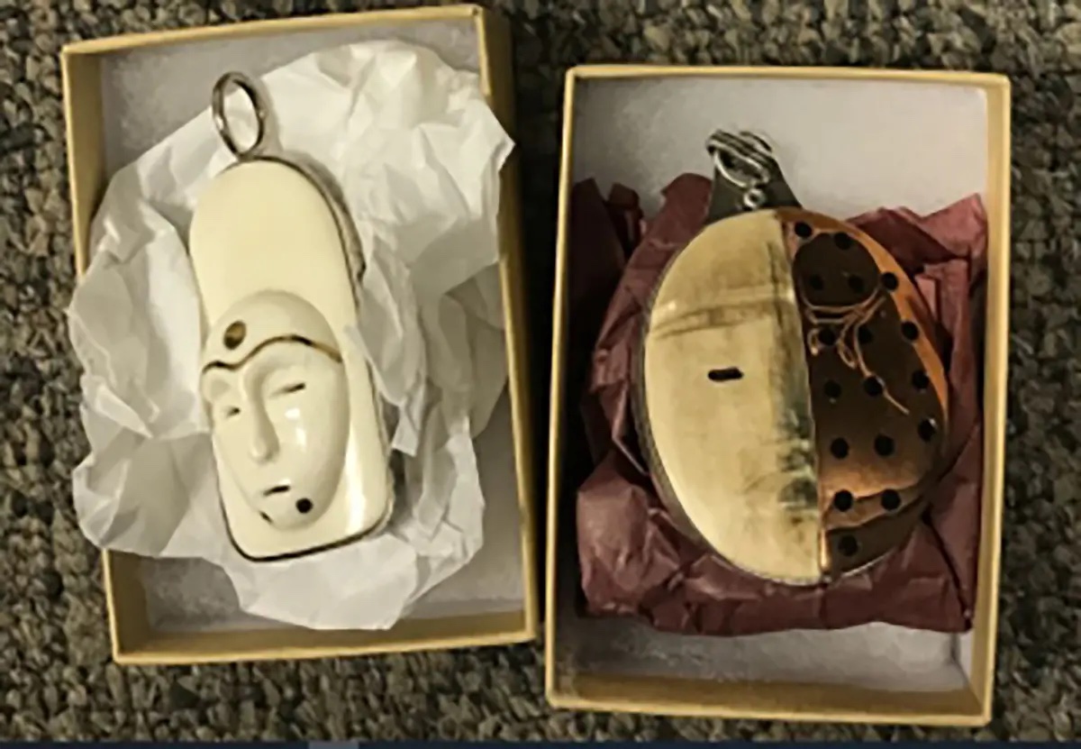 Two masks on crushed paper inside boxes.